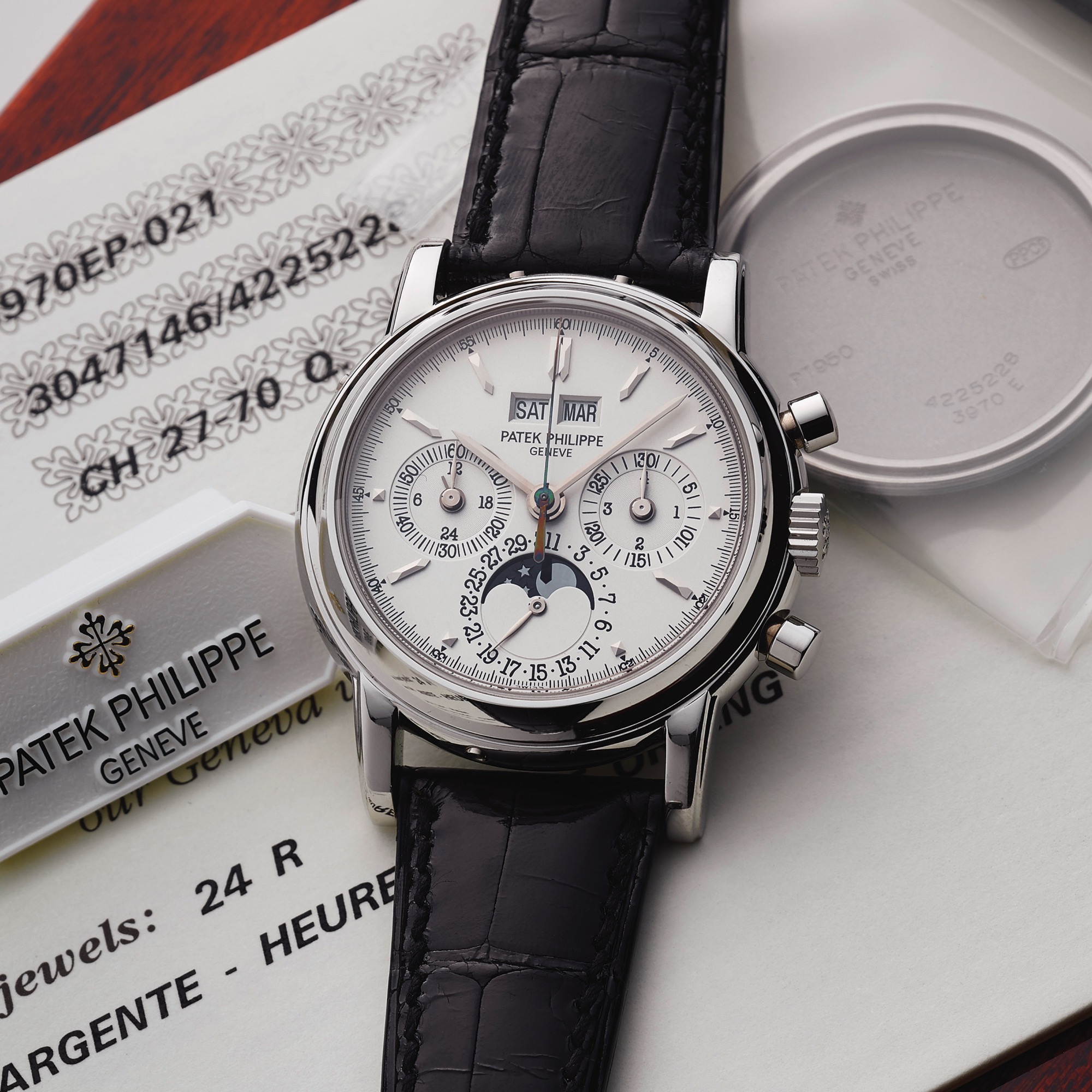 PATEK PHILIPPE REF. 3970 EP SILVER DIAL PLATINUM BOX AND PAPERS
Patek Philippe, Genève, No. 3047146, Case No. 4225228, Ref. 3970EP. Sold September 6th, 2004. 
Very fine and important, water-resistant platinum wristwatch with round button chronograph, register, 
perpetual calendar, moon phases and a platinum Patek Philippe deployant clasp. Accompanied by the original 
fitted box, Certificate of Origin, setting pin, booklet, hang tag, instruction booklet and the additional solid 
platinum cas