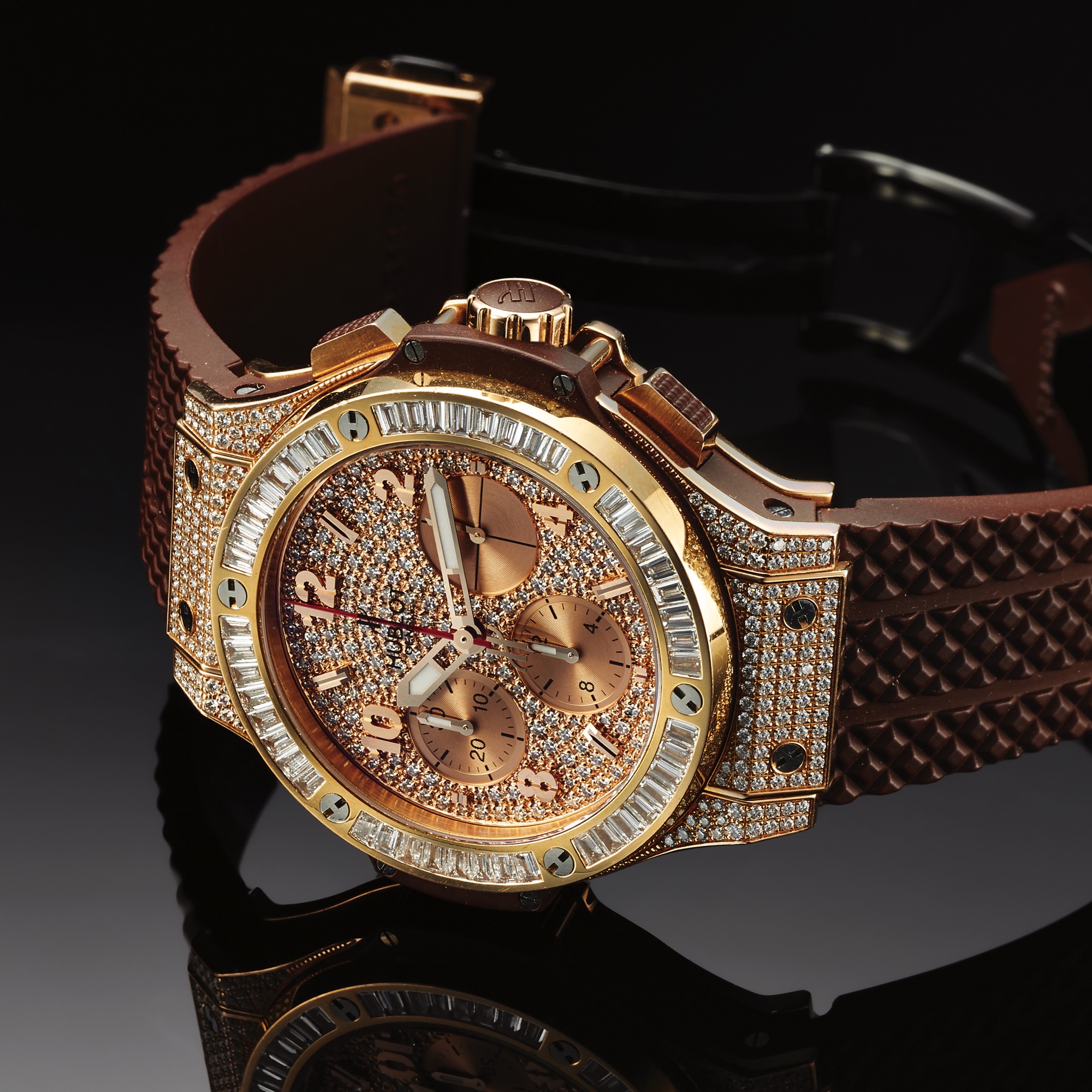 HUBLOT REF. 341 BIG BANG CHRONO
DIAMOND AND PINK GOLD
Hublot, Genève, Big Bang, Chronograph, Automatic, Ref. 341. Made circa 2008. 
Fine and unusual, self-winding, water-resistant, 18K pink gold and diamond, titanium and kevlar wristwatch with square button chronograph, registers and a special integrated rubber strap with a pink gold and stainless 
steel Hublot deployant clasp.
