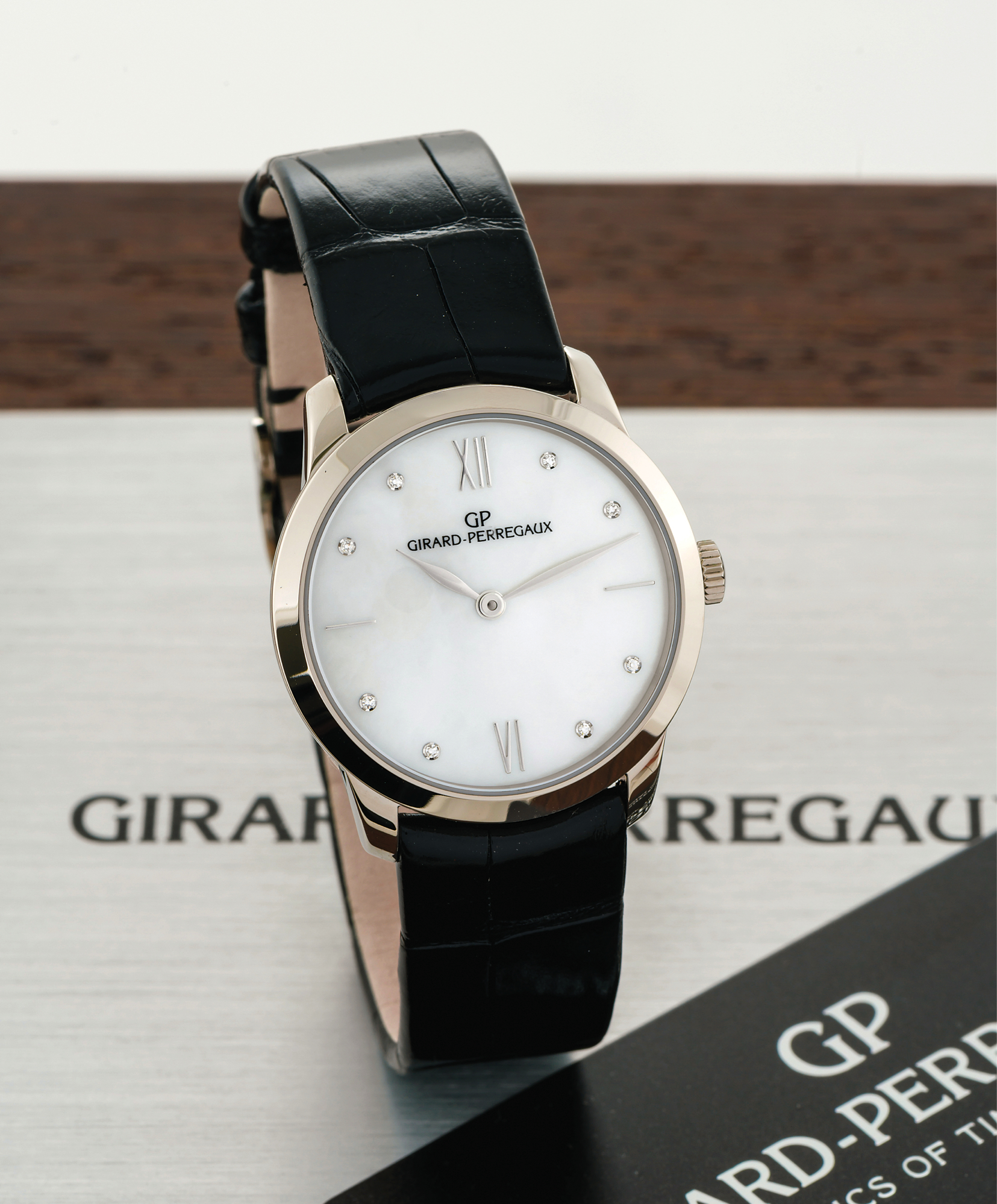GIRARD PERREGAUX MOTHER-OF-PEARL DIAL WHITE GOLD 
Girard-Perregaux, "Automatic," No. 845, Ref. 49528. Made circa 2010. 
Very fine, self-winding, 18K white gold and diamond lady's wristwatch with mother-of-pearl 
dial and diamond indexes and an 18K white gold Girard-Perregaux buckle. Accompanied by 
the original fitted box, blank guarantee card, instruction booklet and hang tag.