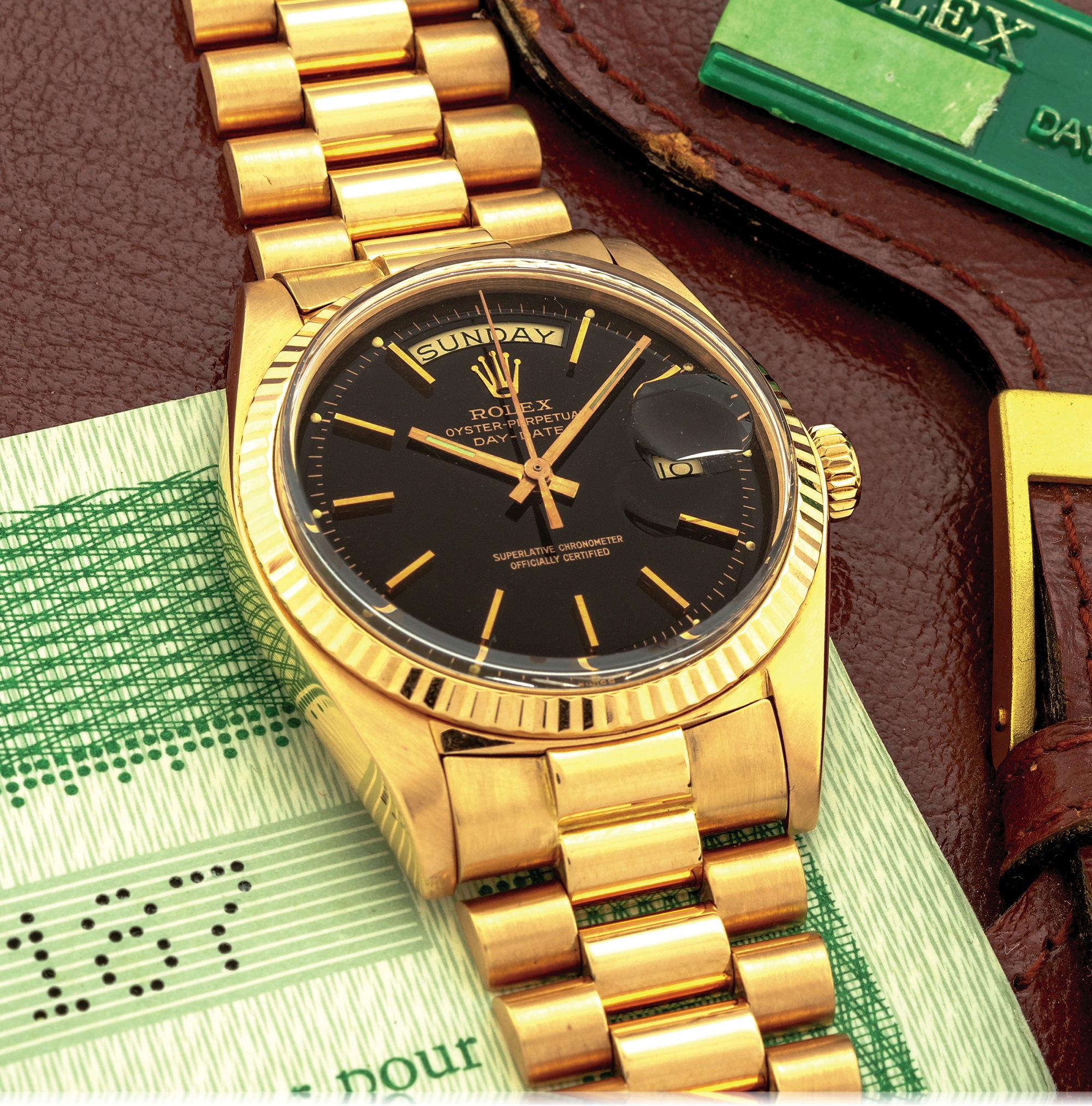 ROLEX REF. 1803 STELLA DIAL "JET BLACK" ORIGINAL BOX GUARANTEE & TAG PINK GOLD 
Rolex, "Oyster Perpetual, Day-Date, Superlative Chronometer Officially Certified", case No. 3276187, Ref. 1803. Made in 1971. 
Very fine and rare, tonneau-shaped, center-seconds, self-winding, water-resistant, 18K pink gold wristwatch with day and date and an 18K pink gold Rolex president bracelet with concealed deployant clasp. 
Accompanied by a Rolex box, original guarantee and hang-tag