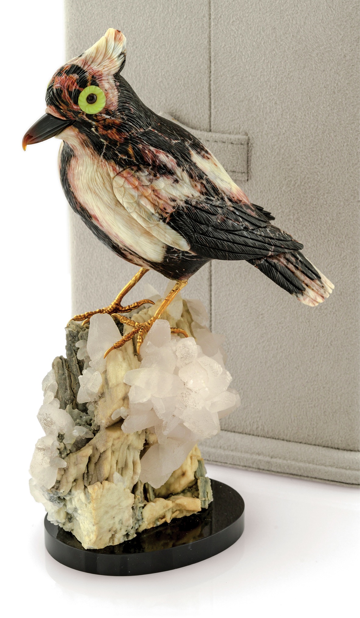 ERWIN KLEIN FOR VACHERON CONSTANTIN 
HARDSTONE BIRD SCULPTURE 
Erwin Klein for Vacheron Constantin, Genève. Made in the 
1980s. 
Fine gold, mottled hardstone, agate and quartz bird 
sculpture. Accompanied by a fitted box. 
Realistically modeled black and white crested bird with 
veined hardstone body, agate hooked beak and cabochon 
ruby eyes, gold feet on a natural quartz crystal base 
and oval black onyx base. 
Signed on a gold disc set into the body of the bird.