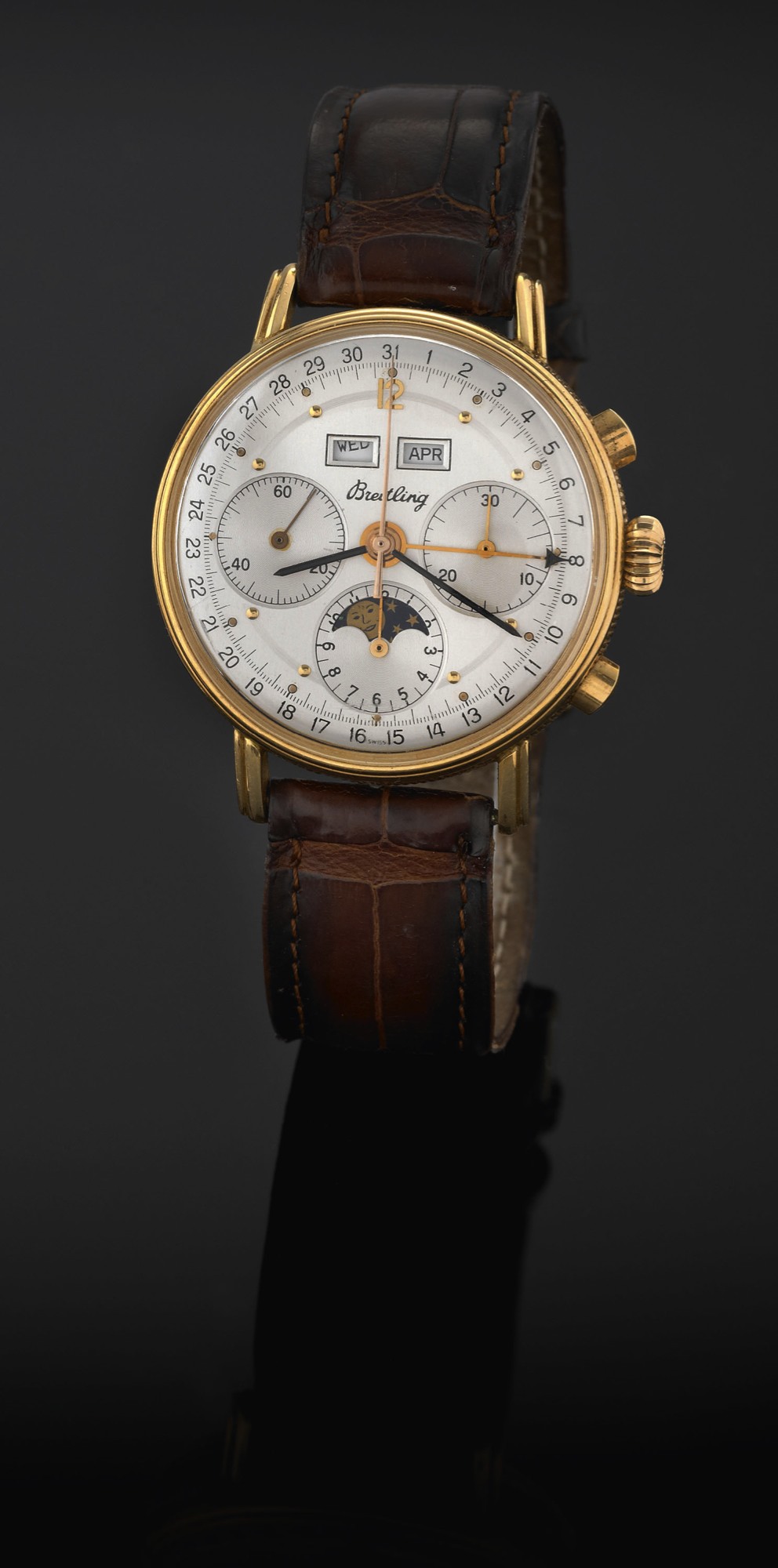BREITLING TRIPLE DATE, CHRONOGRAPH,
YELLOW GOLD
Breitling Genève. Made in the 1950s.
Fine and rare, astronomic, 18K yellow gold wristwatch with
oval-shaped button chronograph, registers, triple date, moon
phases and an 18K yellow gold Breitling buckle.