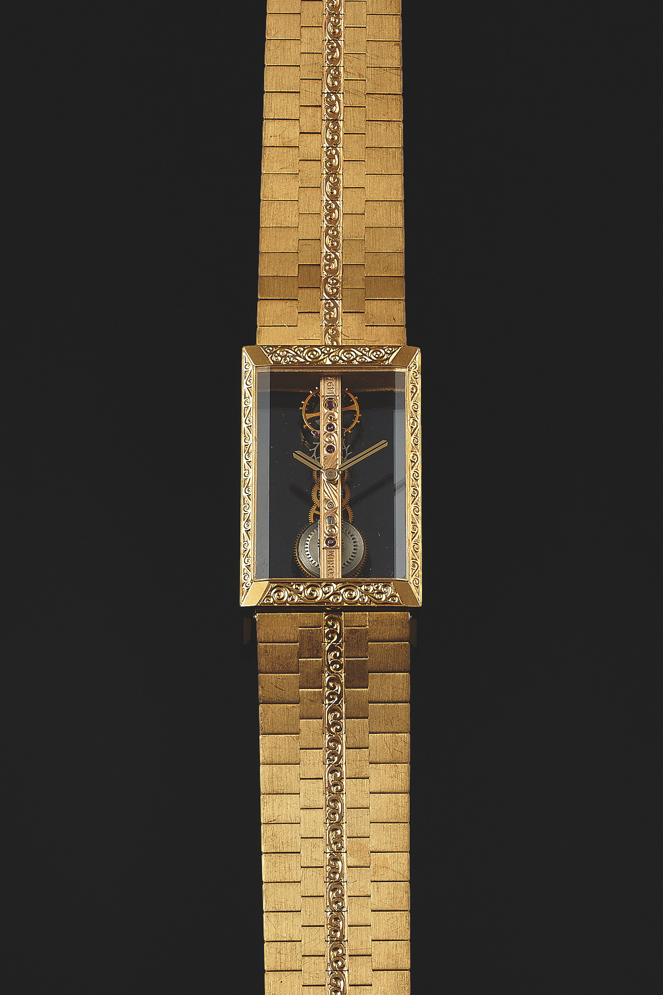 CORUM REF. 1320H12
GOLDEN BRIDGE YELLOW GOLD
Corum, Golden Bridge, No 1497, case No. 107551, Ref. 13205H12. Made in the late 1980s.
Very fine and unusual, rectangular, 18K yellow gold wristwatch, with visible engraved special gold movement, all wheels and pinions fitted in a straight line and an integral 18K yellow gold brick link bracelet.