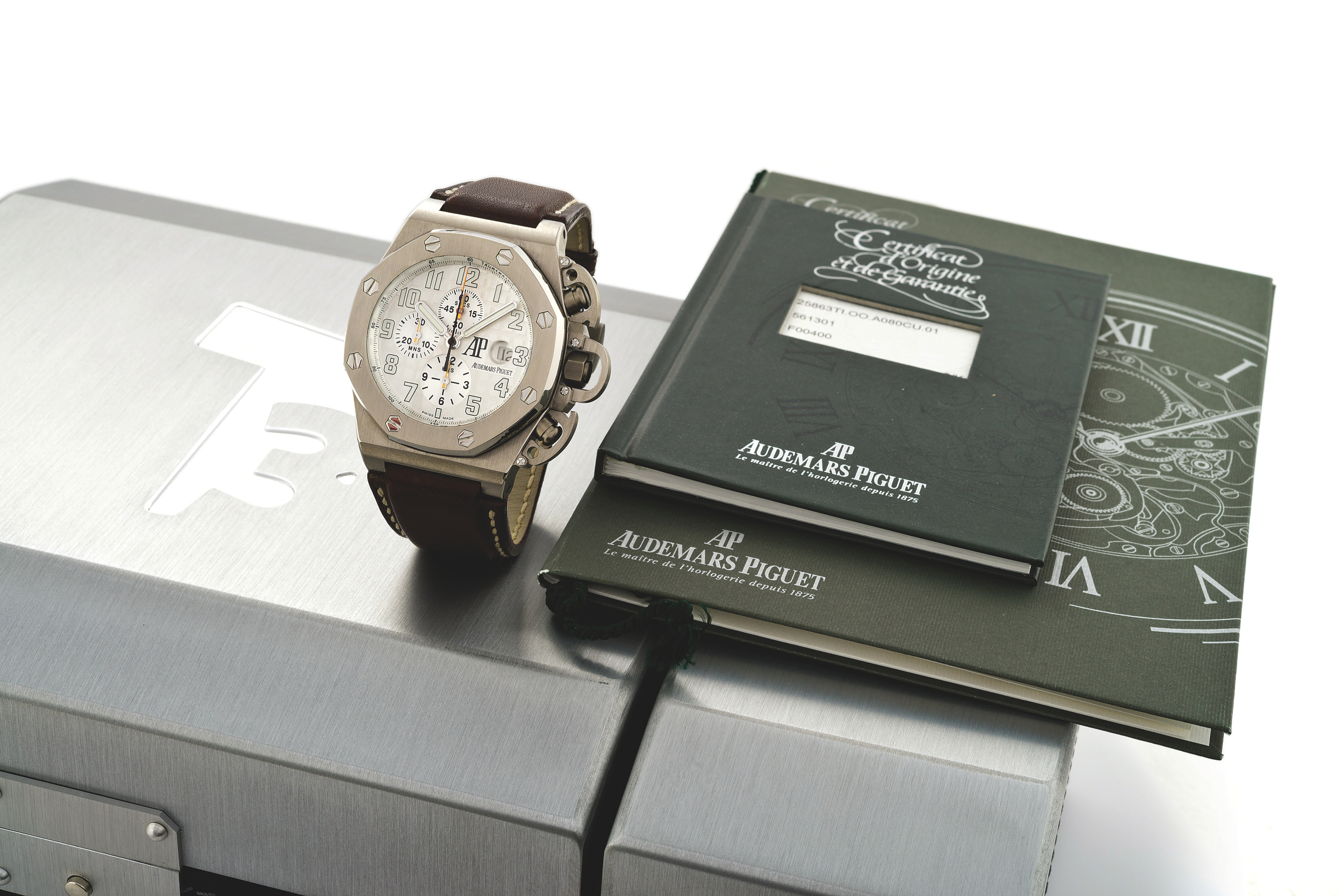 AUDEMARS PIGUET OFFSHORE T3
Audemars Piguet, Genève, ?Royal Oak - Offshore T3?, specially designed in cooperation with Arnold Schwarzenegger for the film ?Terminator 3 - Rise of the Machines?. Movement No. 561301, No. F00400, Ref. 25863Ti. Made in a limited edition of 1000 pieces, sold on November 21st, 2003. Very fine and rare, oversized, octagonal, self-winding, water-resistant, titanium gentleman?s wristwatch with date, round button chronograph, registers, tachometer and an Audemars Piguet t