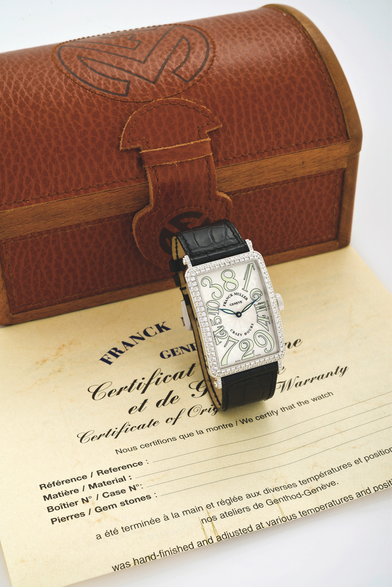 FRANCK MULLER WHITE GOLD & DIAMOND
LONG ISLAND CRAZY HOURS
Franck Muller, Genève, ?Long Island - Crazy Hours,? No. 117, Ref.
1200 CH D. Made circa 2005.
Very fine, large, rectangular curved, self-winding, waterresistant,
18K white gold and diamond-set wristwatch with
non-sequential Arabic numerals, jumping-hours and an 18K
white gold Franck Muller buckle set with 14 white diamonds.
Accompanied by a Franck Muller fitted box, hang-tag and blank
Certificate of Origin.