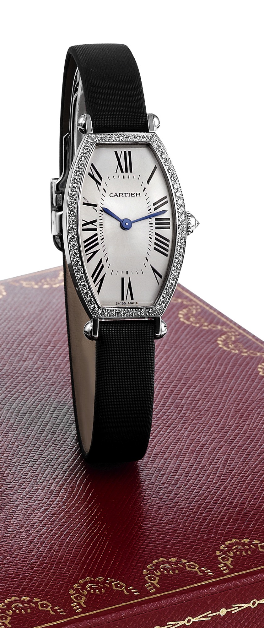CARTIER TONNEAU CINTREE WHITE GOLD AND
DIAMOND
Cartier, Paris, Tonneau Cintrée, No. 21753NX, Ref. 2711.
Made circa 2000.
Fine and elegant, tonneau-shaped, curved, 18K white gold
and diamond-set lady's wristwatch with an 18K white gold
Cartier deployant clasp. Accompanied by a fitted Cartier box,
certificate and booklets.