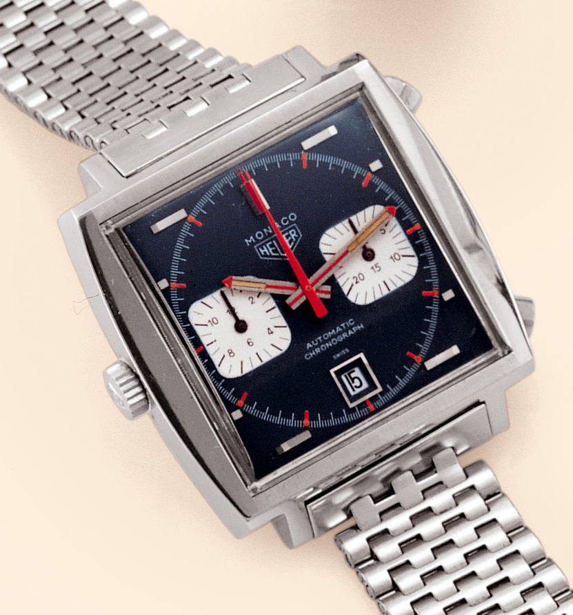 "Monaco"  Heuer, "Monaco", Automatic, Chronograph, Ref. 1133 G. Made in the 1970s. Fine and unusual, cushion-shaped, stainless steel gentleman's wristwatch with round button chronograph, registers, date and a Heuer stainless steel link bracelet and clasp.