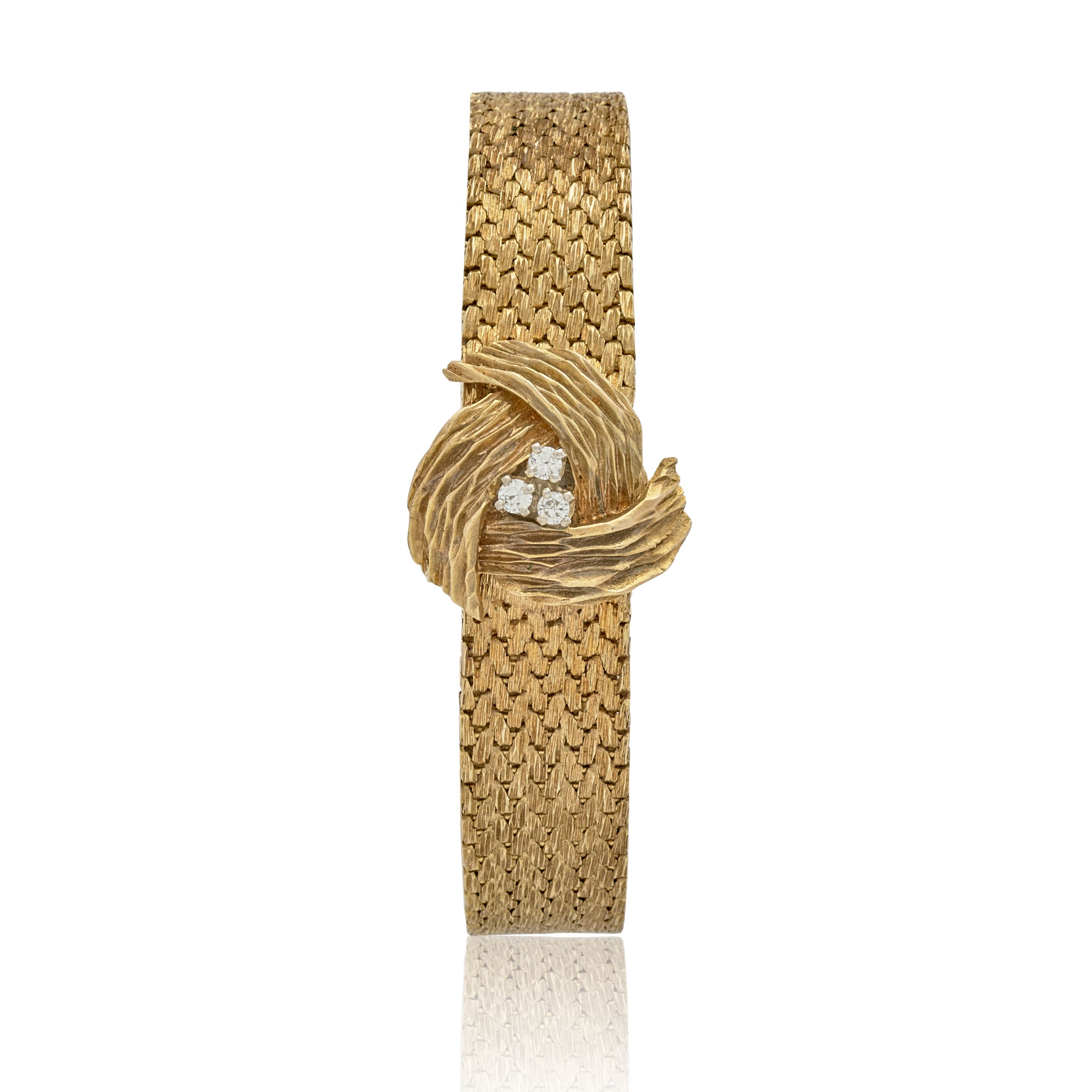 BAUME & MERCIER. A 14K GOLD LADY'S MANUAL WIND BRACELET WATCH WITH CONCEALED DIAL