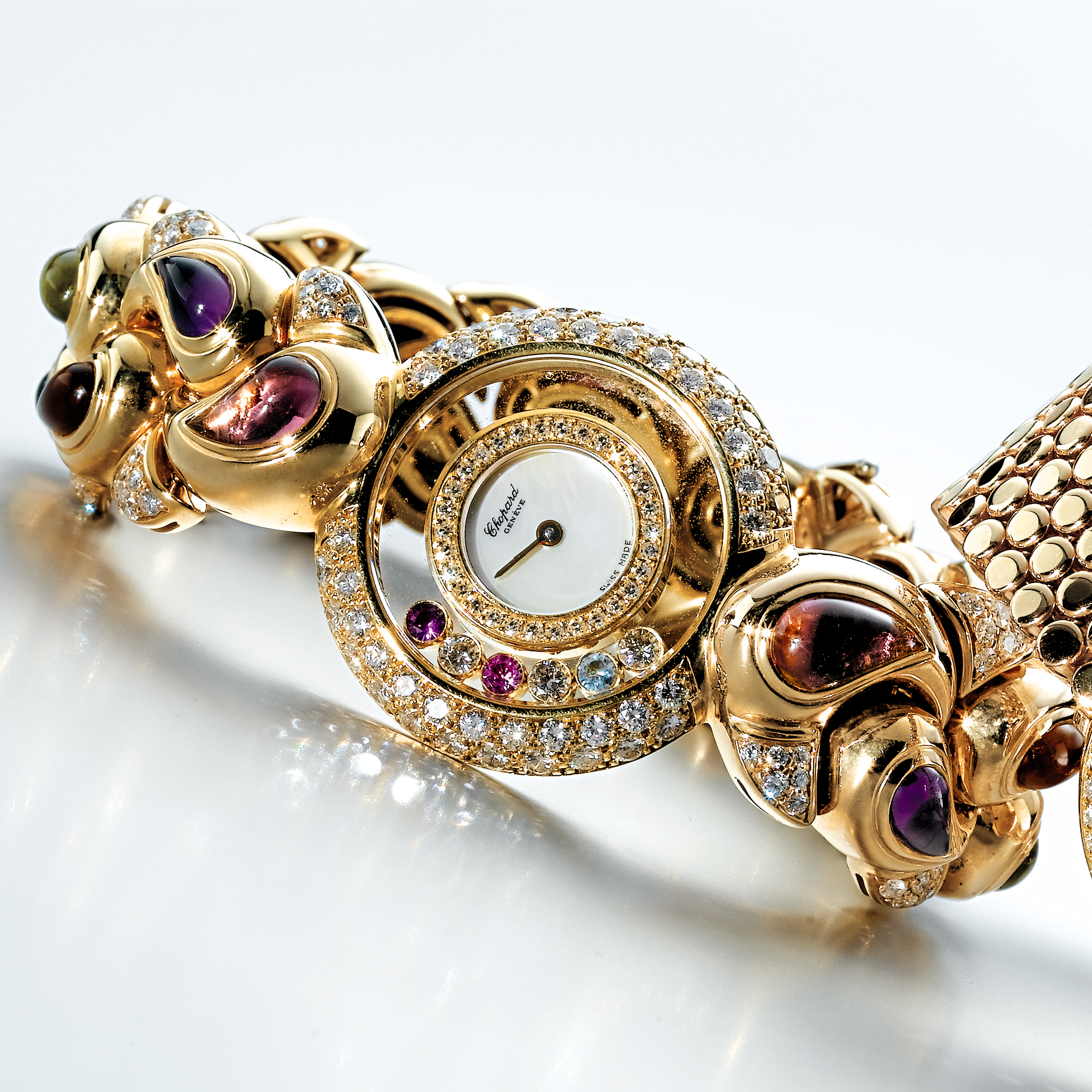 CHOPARD, A LADY'S GOLD, DIAMOND AND COLOURED SAPPHIRE BRACELET WATCH WITH MOTHER-OF-PEARL DIALCIRCA 2003