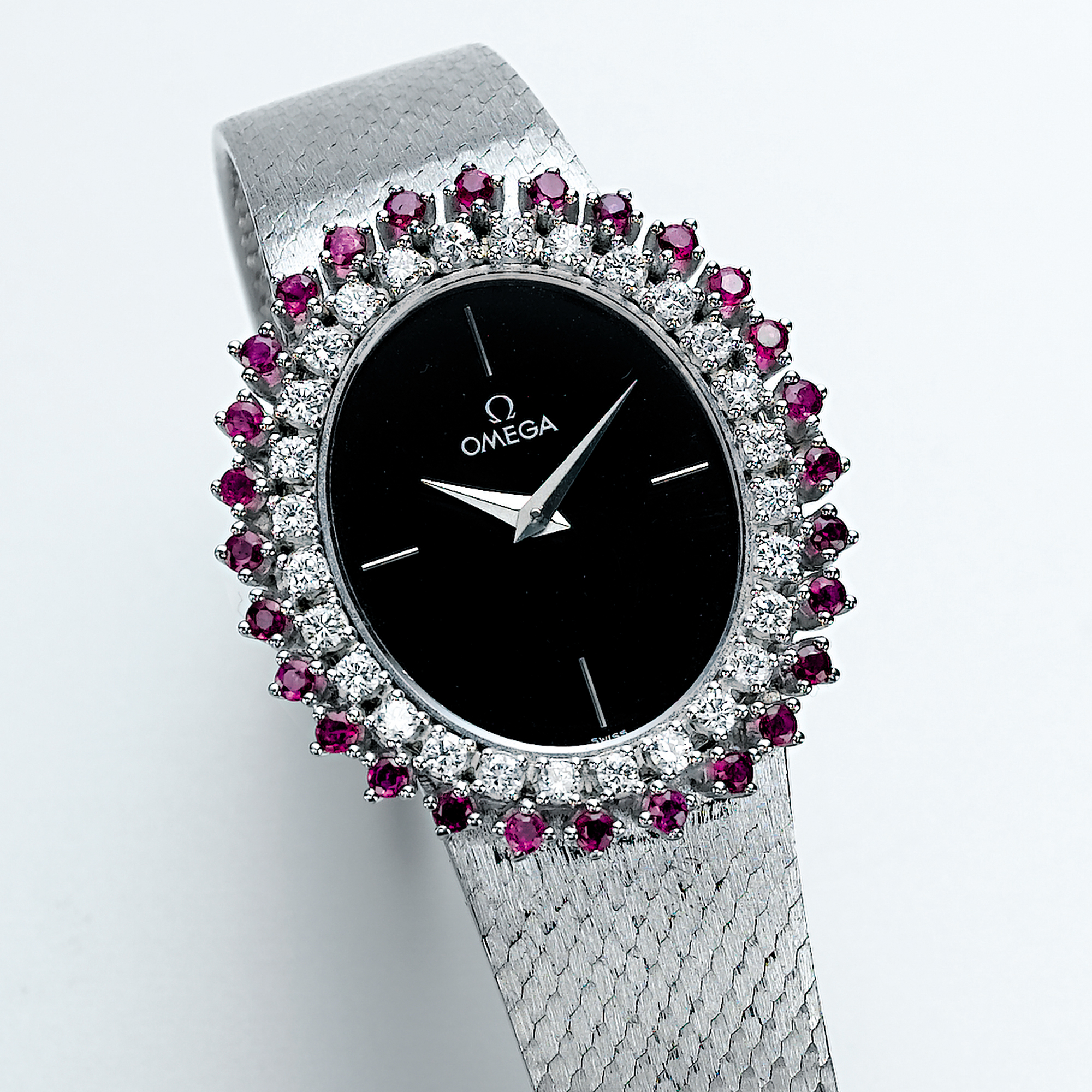 OMEGA, A LADY'S WHITE GOLD, DIAMOND AND RUBY SET OVAL BRACELET WATCHCIRCA 1970