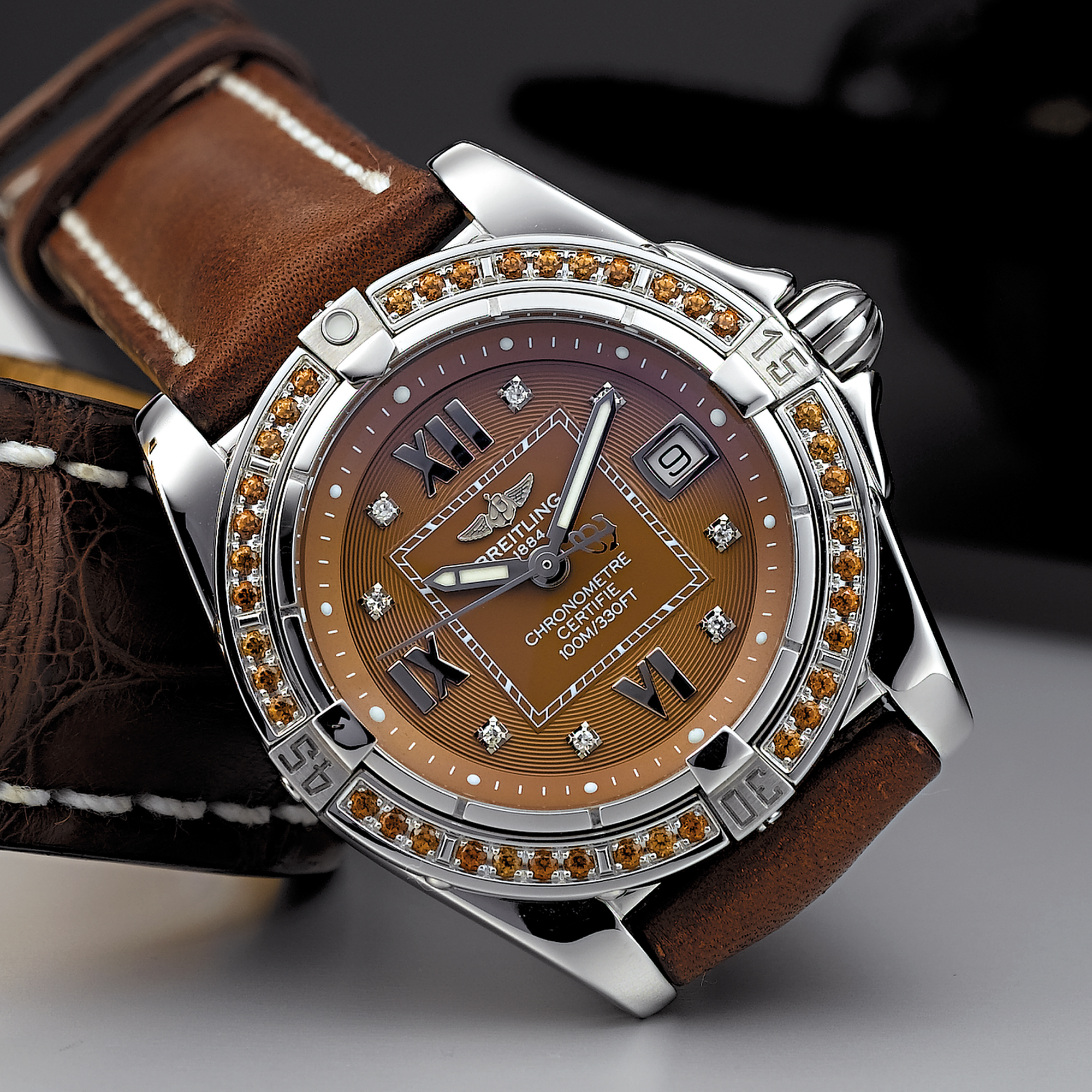 BREITLING, A LADY'S STAINLESS STEEL, DIAMOND AND COLOURED SAPPHIRE SET WRISTWATCH WITH DATECOCKPIT, CIRCA 2003