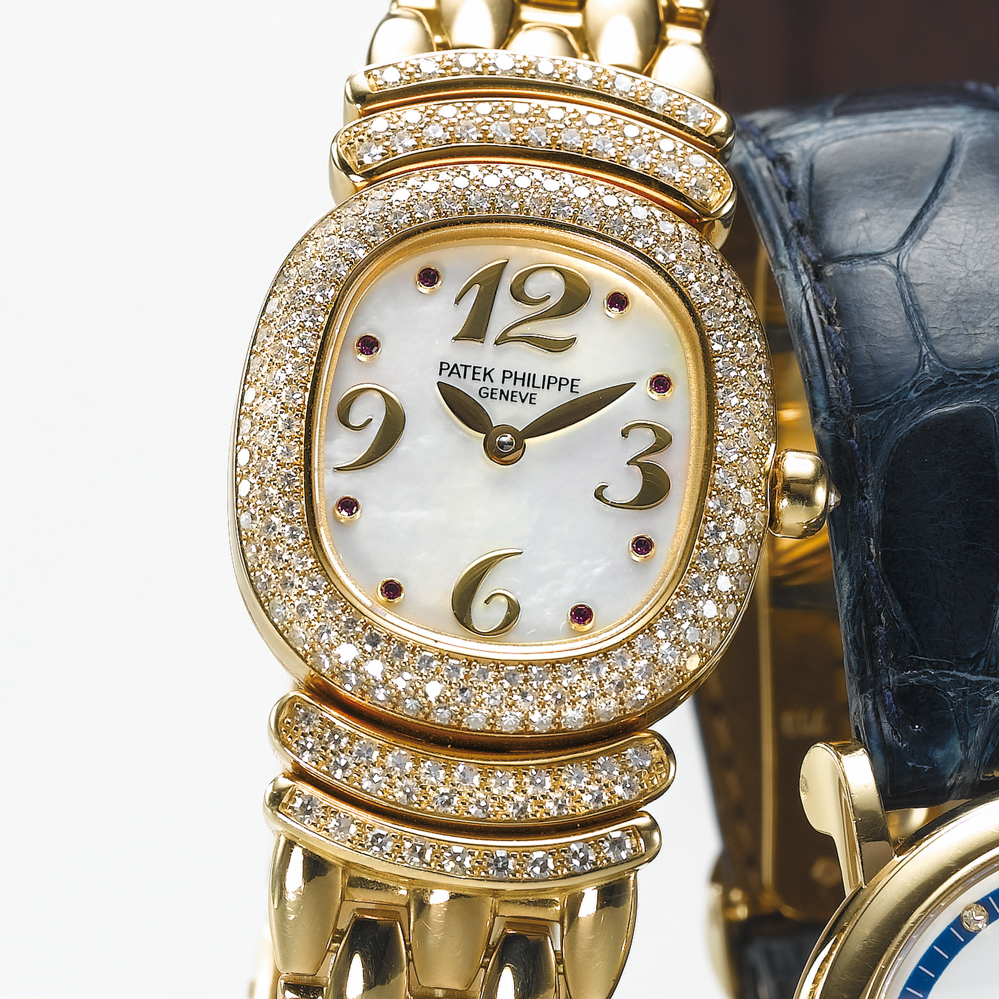 PATEK PHILIPPE, A LADY'S FINE GOLD, DIAMOND AND RUBY SET ELLIPTICAL WRISTWATCH WITH MOTHER-OF-PEARL DIAL AND BRACELETGOLDEN ELLIPSE, CIRCA 1987, NO. 1.623.152, REF. 4831/11 